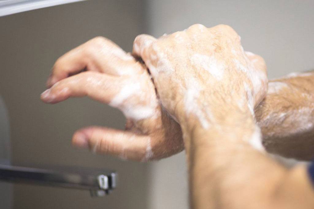 Surgeon in hospital surgery washing hands in sterile uniform 'scrubs' before operating theater emergency room. No model release require because not recognizable model.