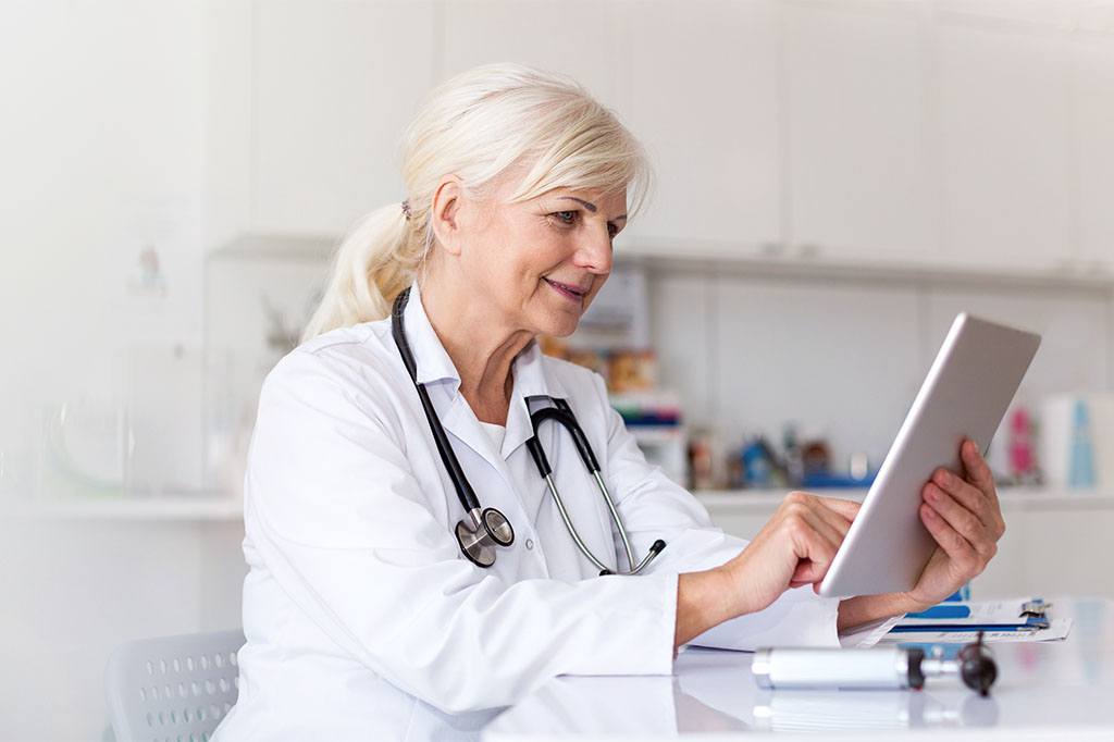 Female doctor using digital tablet in her office.